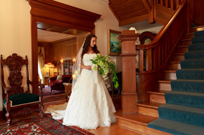 A beautiful bride stands in the entrance to the mansion