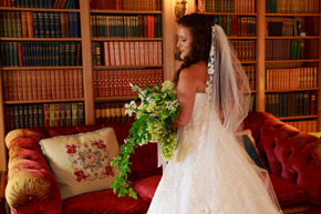 A beautiful bride stands in the Library of the Frank Phillips Mansion