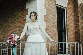 A bride looks out on the lawn from the Veranda