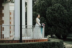 A bride looks out on the lawn from the Veranda