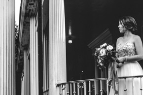 A bride looks out on the lawn from the Veranda